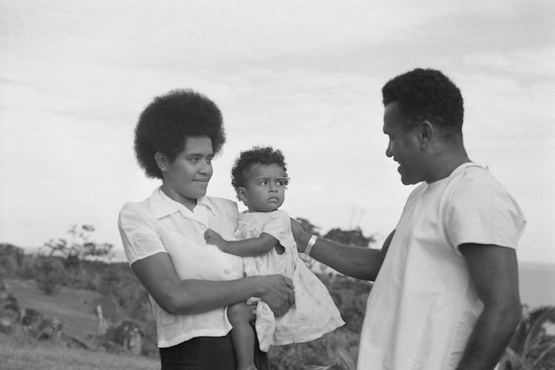 Taione Sikivou (right), leader of the Kadavu Island Yaws Team examining babies for yaws in the village of Namara in 1955.